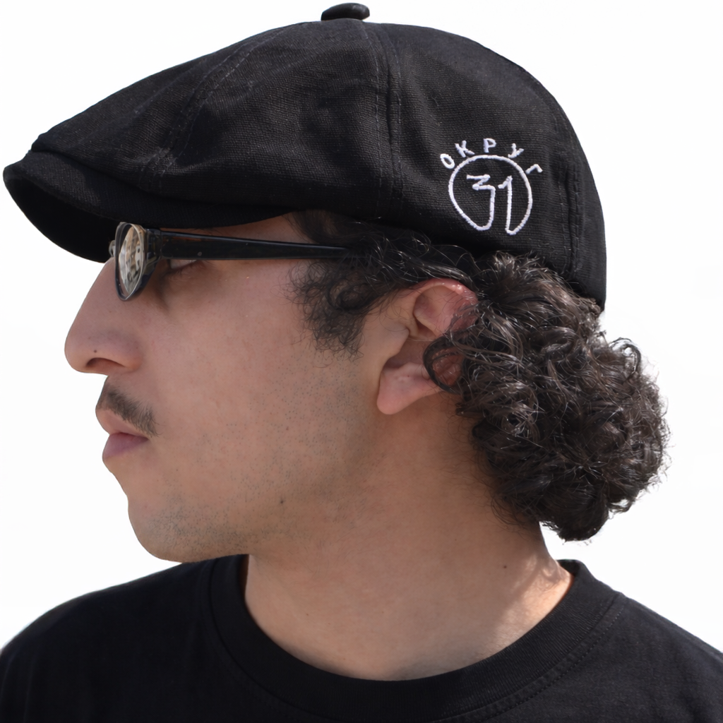 Man wearing a sk9 black cap with a logo on a white background