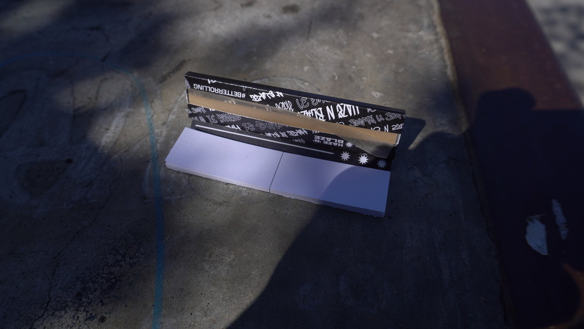 Two black and gold rectangular objects on a textured surface