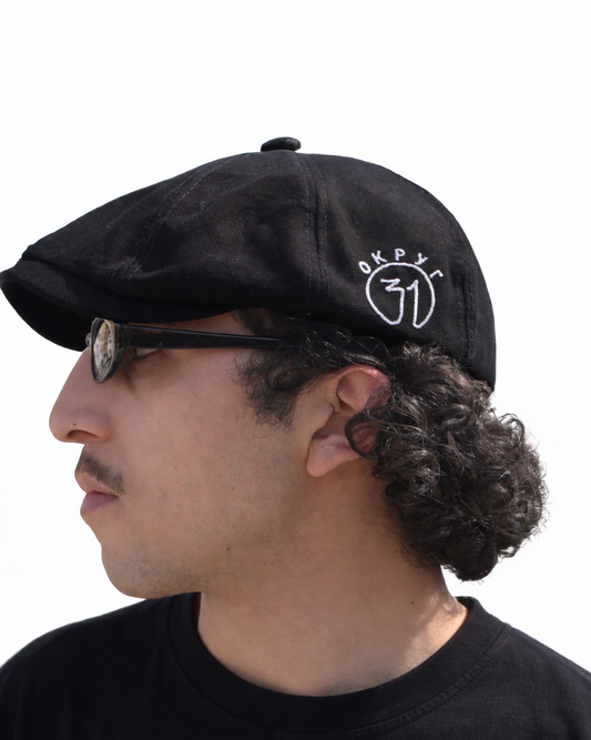Man wearing a black cap with a logo on a white background